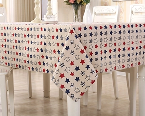 Close-up of poly-cotton tablecloth featuring red and blue star patterns on beige fabric