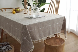 Close-up of oatmeal plaid tablecloth with cotton linen texture and fringe trim edges