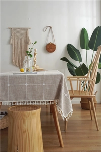 Detail of Nordic plaid tablecloth with elegant white cotton tassel fringe and woven texture