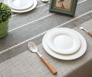 Detail of gray jacquard table runner with geometric woven lines and cotton linen texture