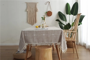 Detail of grid pattern linen tablecloth with decorative white tassel fringe edges