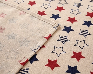 Close-up of red and blue star pattern tablecloth with detailed hemmed edge stitching