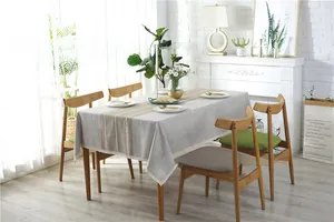 Detailed view of grey linen tablecloth with vertical stripes and white lace fringe