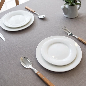 Close-up of grey waterproof tablecloth with textured fabric and tassels on a dining table