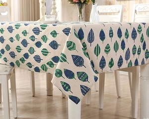 Close-up of linen blend tablecloth with Nordic hand-painted green leaves pattern