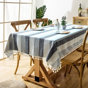 Close-up of waterproof striped linen tablecloth with decorative white tassel lace edges
