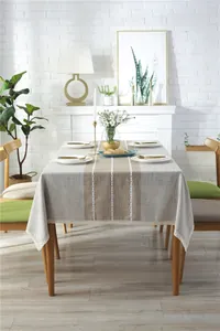 Detail of striped linen-textured tablecloth with white embroidery and lace trim edges