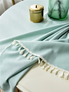 Detail shot of mint green waterproof tablecloth with textured fabric and white fringe