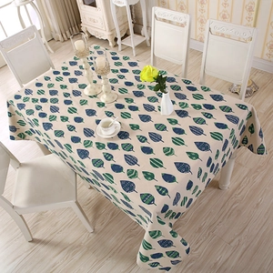 Cozy home setting showing beige striped tablecloth with blue and green leaf patterns