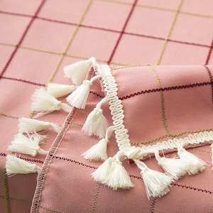 Macro detail of pink plaid tablecloth with thick texture and white tassel lace trim