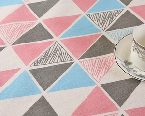 Detailaufnahme der Tischdecke mit geometrischem Dreiecksmuster in Rosa und Blau auf Leinen