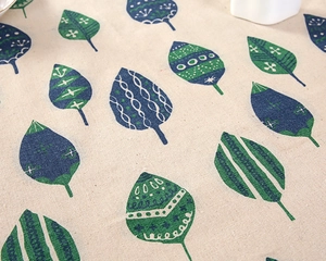 Close-up of cotton linen tablecloth with creative forest green leaf pattern and stripes
