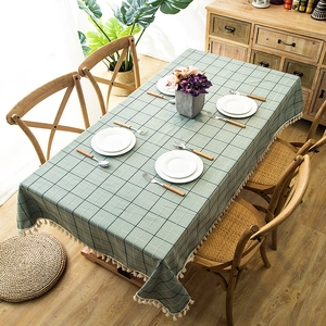Detail of grey-green waterproof plaid tablecloth with elegant white handmade fringe trim