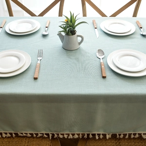Detail of light teal waterproof tablecloth featuring cotton linen texture and fringe trim