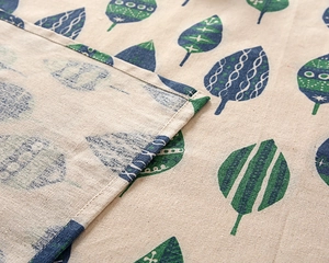 Detail view of the high-quality stitching and green leaf pattern on the fabric