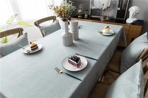 Detail of light blue-grey tablecloth with colorful polka dot embroidered tassel edges
