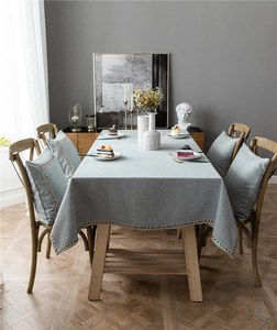 Close-up of modern grey-blue tablecloth and chair cushions with geometric lace details