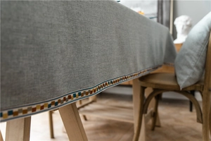 Detail of waterproof cotton linen tablecloth with colorful woven geometric lace trim