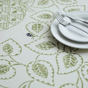 Detailed macro shot of thick cotton canvas tablecloth with green leaves and ladybugs