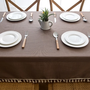 Close-up of dark brown waterproof tablecloth with elegant white tassel fringe edges