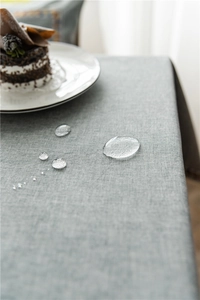 Waterproof polyester cotton tablecloth close-up showing water droplets on gray fabric