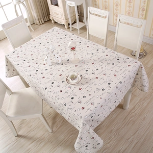 Detail of nautical print tablecloth with anchors and sailboats on a white wooden table