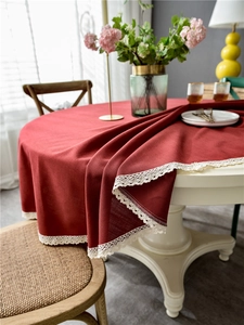 Detail of burgundy round tablecloth with elegant beige lace trim for dining decor