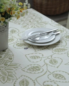 Detail of cotton canvas tablecloth with green leaves and geometric floral patterns