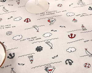 Macro shot of nautical theme table cloth with anchors, sailboats and seagulls pattern