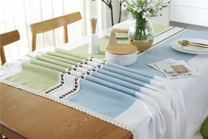 Detailed close-up of colorful linen table runner with lace trim and tassel embroidery