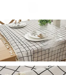 Detailed close-up of modern black and white plaid tablecloth with white cotton tassels