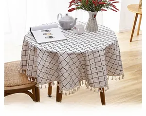 Detail of round black and white checkered tablecloth with decorative white fringe tassels