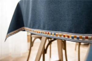 Detail view of navy blue tablecloth with colorful geometric ribbon and fabric texture