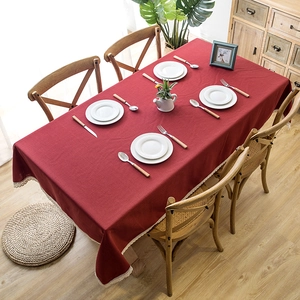 Close-up of deep red linen-textured tablecloth with elegant white lace fringe details