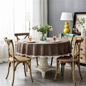 Detailed view of dark brown round tablecloth with elegant white lace fringe edges