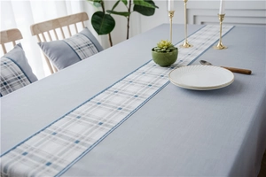 Detail of waterproof light blue table runner with geometric plaid patterns and textured fabric