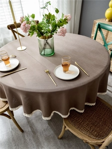 Detail of round dark brown tablecloth with elegant white lace trim for dining tables