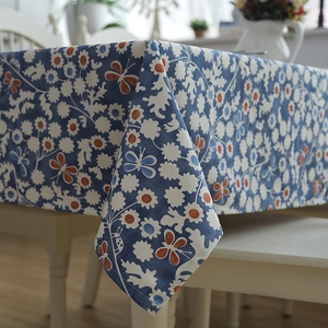 Close-up of thick cotton canvas tablecloth with blue and orange floral daisy pattern