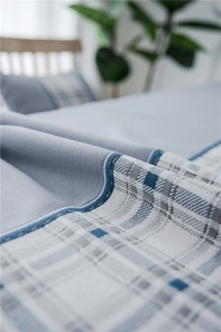 Detailed close-up of blue linen textured fabric with geometric pattern and edge stitching
