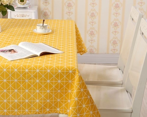 Detailaufnahme der gelben rechteckigen Tischdecke mit weißem Gittermuster in wohnlichem Design