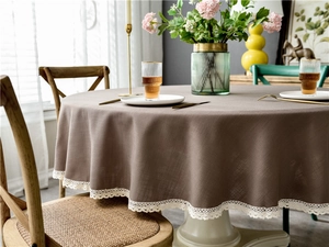 Detail of mocha brown linen texture round tablecloth with white lace tassel trim