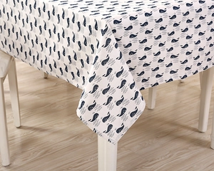 Close-up of cotton linen tablecloth with blue whale patterns and neat edge stitching
