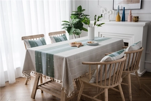 Detail of Nordic linen style tablecloth with blue stripes and elegant fringe tassels