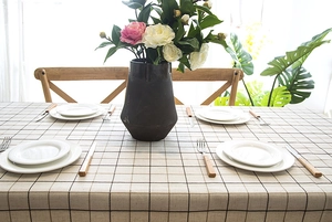 Close-up of geometric plaid tablecloth with fringe details and jacquard texture for home decor