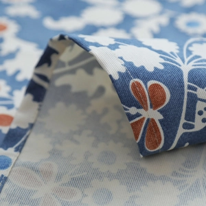 Detailed macro view of the blue floral cotton canvas fabric texture and stitched hem edge