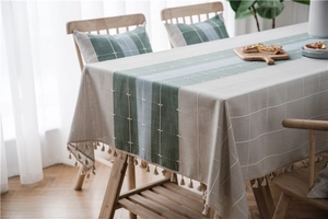 Detail of Nordic plaid table runner with fringe tassels and soft linen texture
