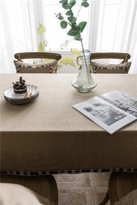 Detail of coffee brown linen-textured tablecloth featuring colorful polka dot lace trim
