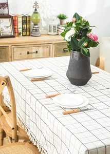 Detail of checkered tablecloth with fringe edges and rustic linen texture in a home setting