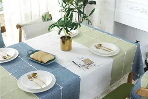 Close-up of textured linen tablecloth with fringe tassels and geometric color blocks