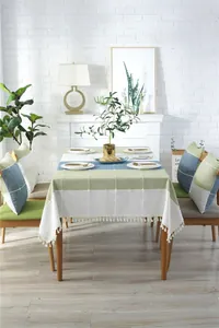 Close-up of geometric plaid tablecloth featuring white tassel fringe and cotton-linen texture